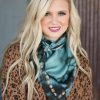Blonde woman smiling her Fringe Scarf, Kingman Turquoise that compliments her Western fashion.