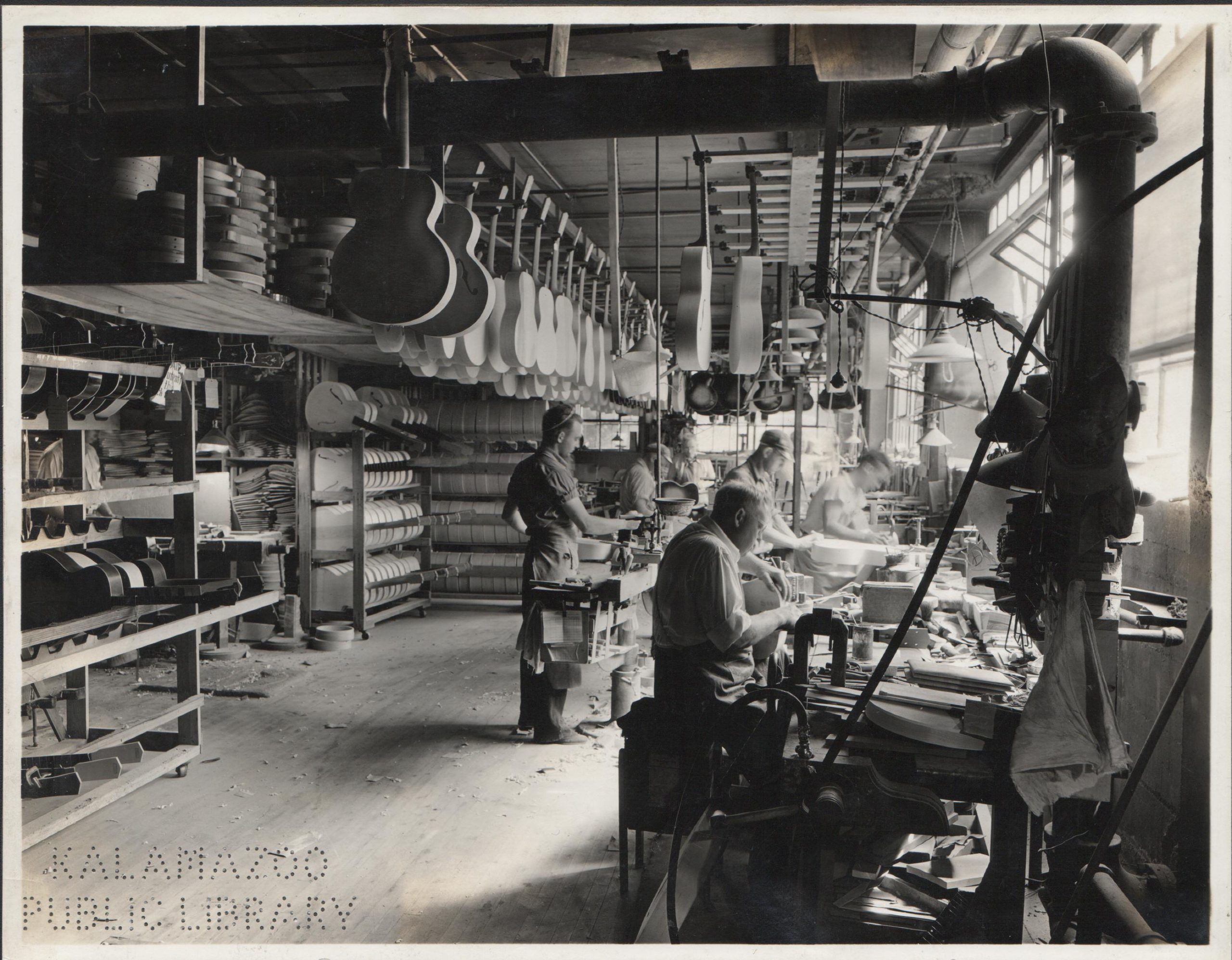 Factory workers crafting guitars in Gibson's Kalamazoo warehouse circa 1936.