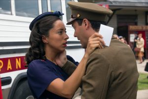 Actor Scott Eastwood dons a vintage military outfit and embraces actress Britt Robertson, wishing her goodbye before boarding the bus in the background, in the 2015 film "The Longest Ride."