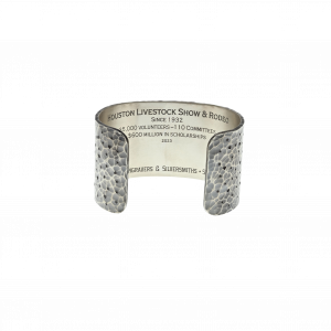 The inside of the Clint Orms Houston Rodeo silver cuff, engraved with "Houston Livestock Show & Rodeo, Since 1932, 35,000 Volunteers, 110 Committees, $600 million in scholarships, 2023."