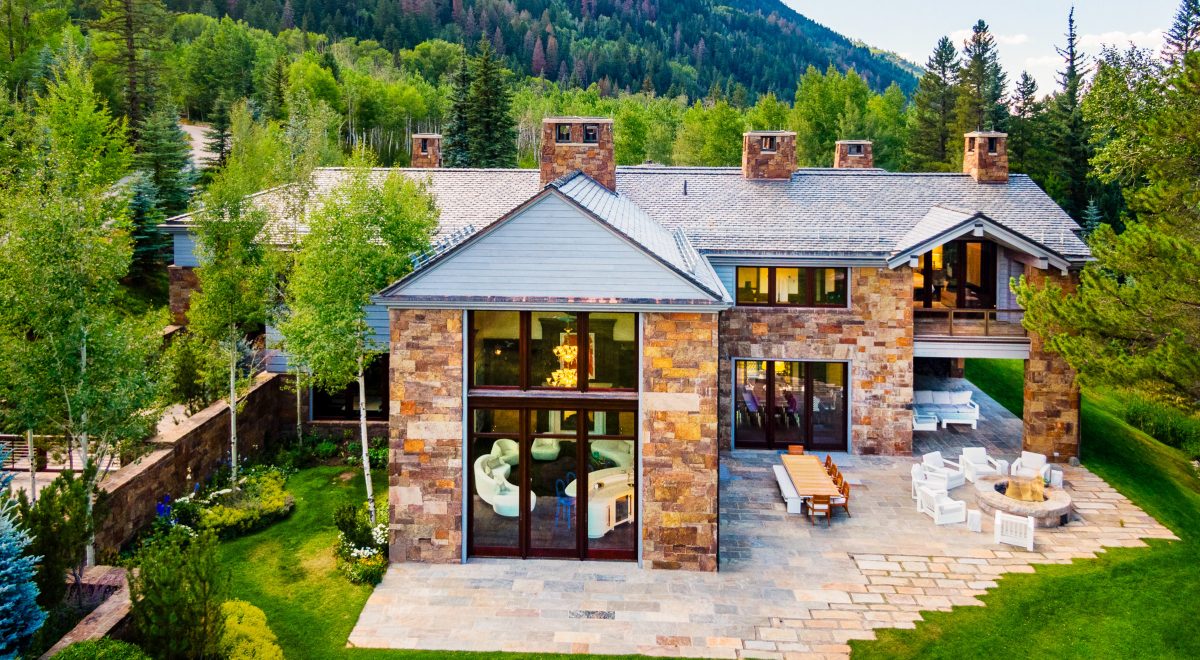 The exterior of the property from the back, showcasing the house's many windows and back porch.