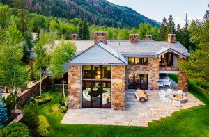 The exterior of the property from the back, showcasing the house's many windows and back porch.