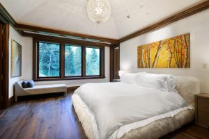 One of the property's guest bedrooms includes a full-sized bed, a lounge chaise, and plenty of natural light.
