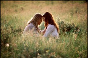 Actors Brad Pitt and Julia Ormond sit in a field of tall grass with their foreheads against one another in the 1994 film "Legends of the Fall."