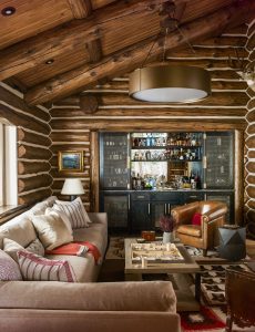 The show-stopping lattice-fronted bar, with bronze forged by local craftsmen, was created by WRJ in partnership with Brandner Design. The iron-and-bronze coffee table is from Baker Furniture and the metal ring chandelier with a bronze finish is by Hammerton. (Architectural Digest)