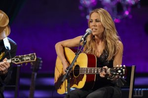 Sheryl Crow performing onstage with her Gibson guitar.