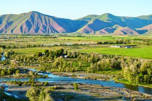 Wide view of Wood River Ranch property, encompassing a river and mountains.