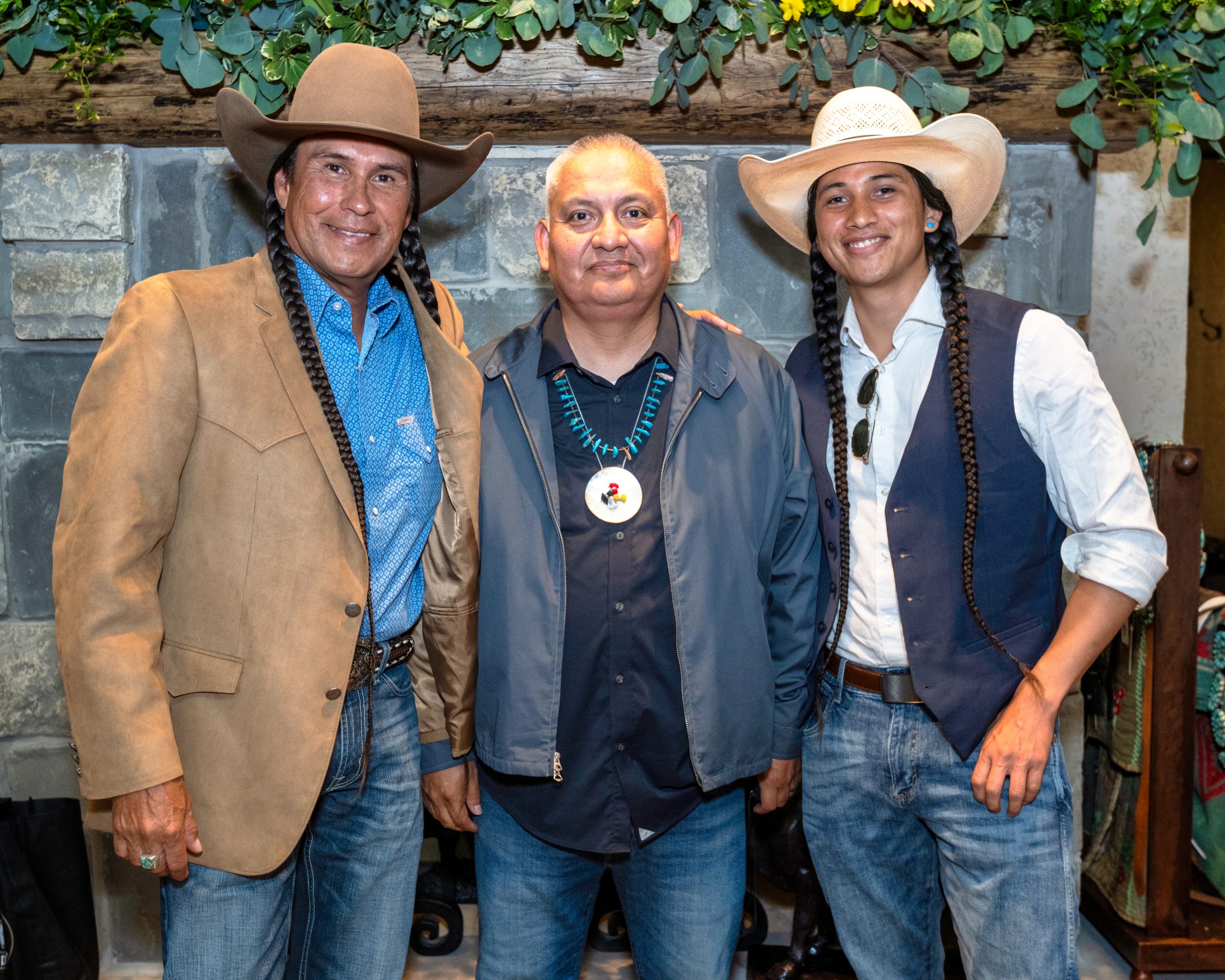 Mo Brings Plenty (left), Eugene Tapahe (middle), and Cole Brings Plenty (right) smile at the camera in the Double D Fort Worth Stockyards storefront.