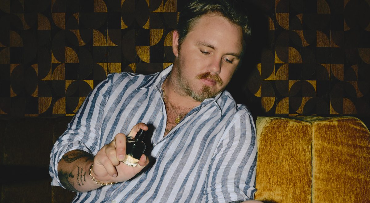 Country singer Ernest spraying his new perfume, 1992 (feat. ERNEST), created in collaboration with Nashville's Ranger Station.