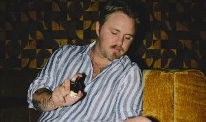 Country singer Ernest spraying his new perfume, 1992 (feat. ERNEST), created in collaboration with Nashville's Ranger Station.