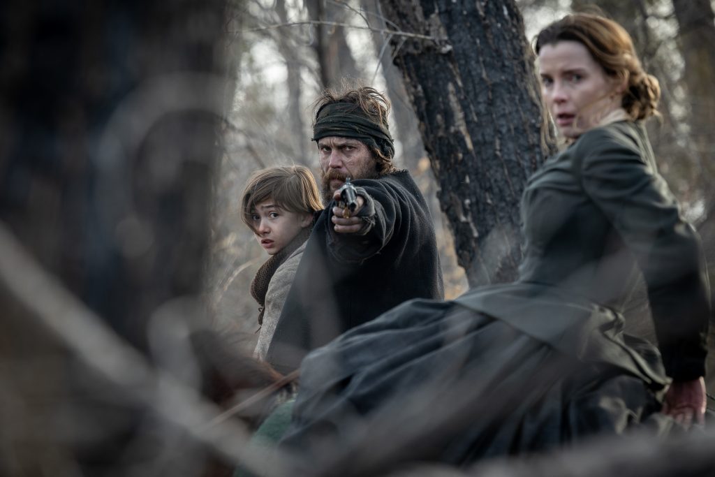 Preston Mota as Devin Rowell, Taylor Kitsch as Isaac, and Betty Gilpin as Sara Rowell in "American Primeval"