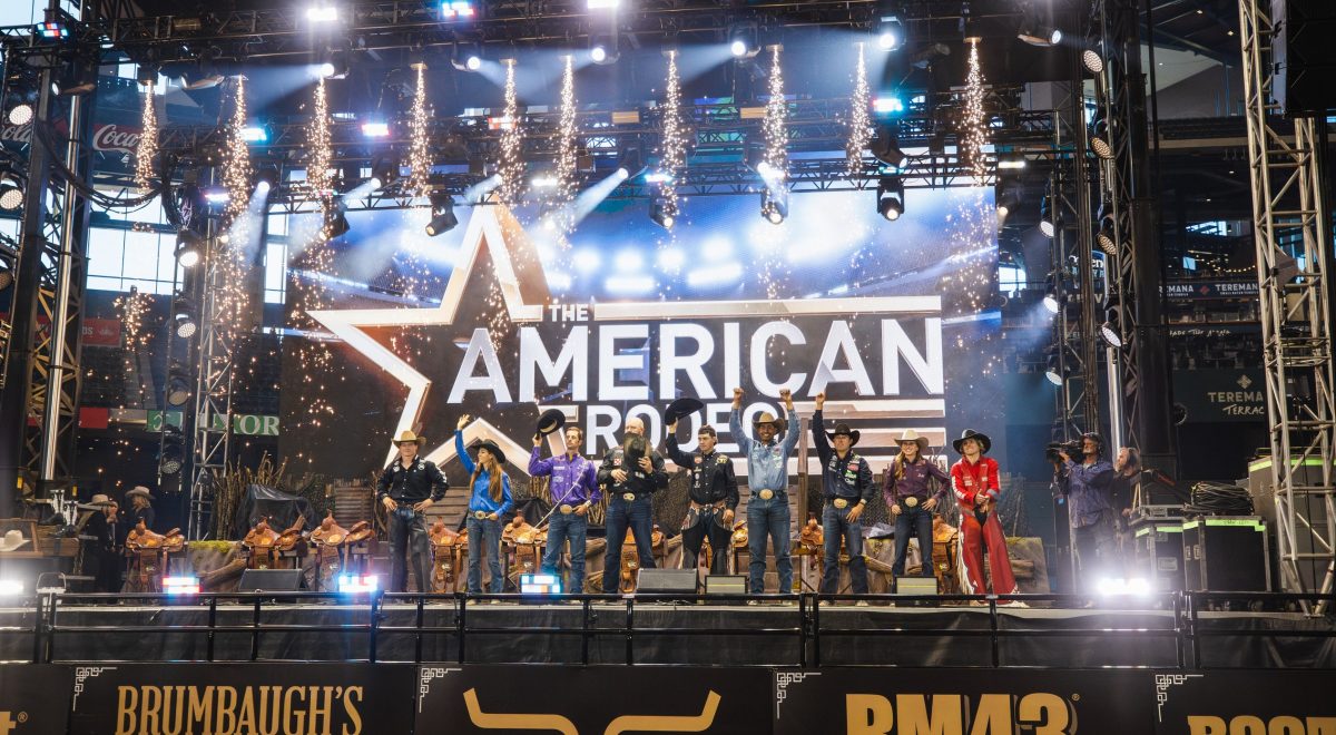 Champions of the 2025 American Rodeo stand on stage.