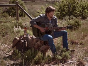 Luke Grimes playing guitar