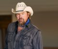 Headshot of Toby Keith in a cowboy hat and blue bandana.