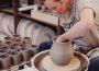 Image of Rachel Sherrill of Studio RK in motion at turntable, creating a ceramic pot.