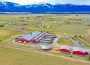 Aerial perspective of Hot Property equine facility barn, displaying spacious stable areas, open fields, outdoor arenas, and large storage barns.